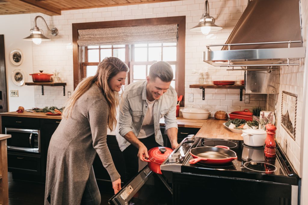 A man and a woman cooking in a kitchen.